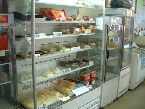 商品のパックや袋詰めの食料品が陳列された、ガラス扉の冷蔵ケースの内部を捉えた店舗内の写真