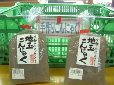緑色のプラスチック製コンテナを背景に、「手作りこんにゃく」と書かれたポップの下で、「地玉こんにゃく」と印字されたビニール袋入りの商品が2つ陳列されている農産物直売所の写真