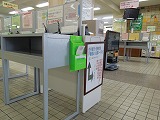 本庁舎に設置された記載台の横にある黄緑色のポストの写真