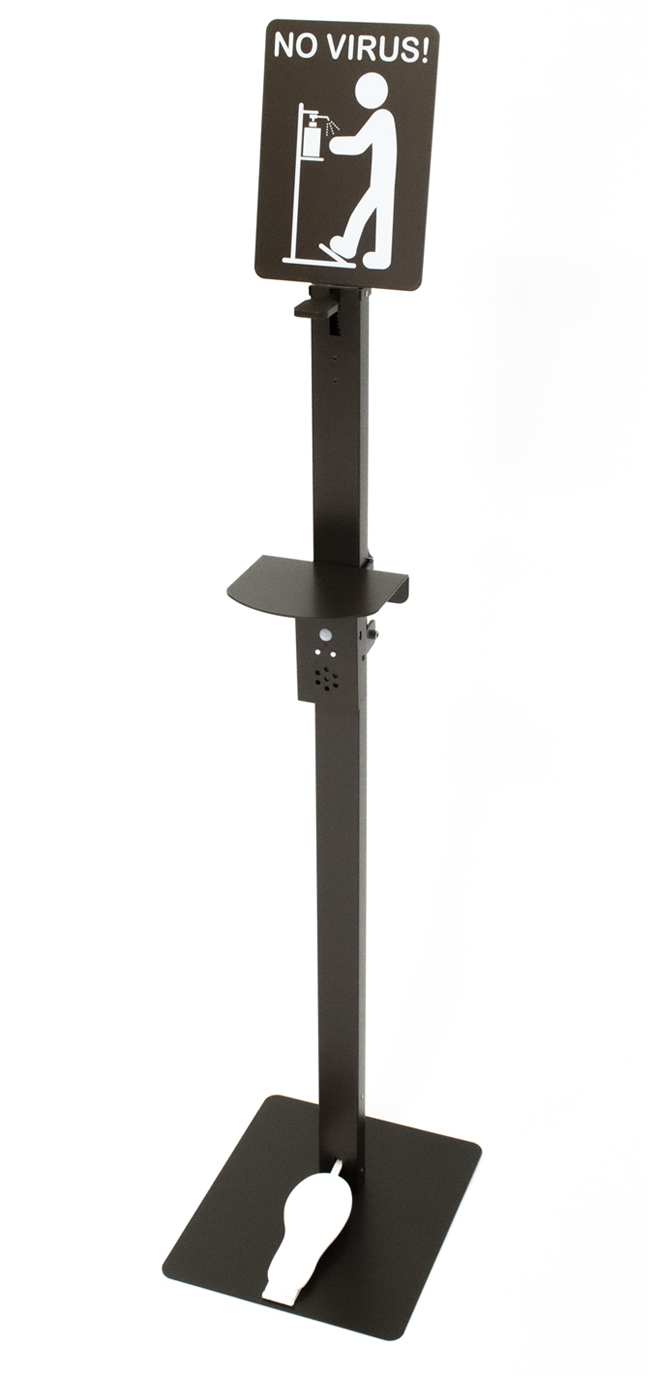 黒い台座と支柱を持つスタンド型消毒液ディスペンサーで、上部に「NO VIRUS!」と書かれた使用方法を示すサインボード、中央に音声案内装置とトレー、下部に足踏みペダルが配置された感染症対策用品の写真