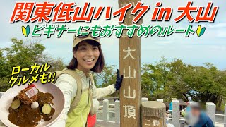 「関東低山ハイク in 大山」と「ビギナーにもおすすめのルート」の文字の下で、山頂の標柱の横に立つかほさんが笑顔でポーズをとり、左下にはローカルグルメのカツカレーの写真が表示されている動画の一部画像