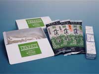 そばの詰め合わせが並べられており、緑色のラベルが付いた白い箱2つと、黒と緑のパッケージに入ったそばが3袋、さらに細長い白い箱が1つ置かれている写真