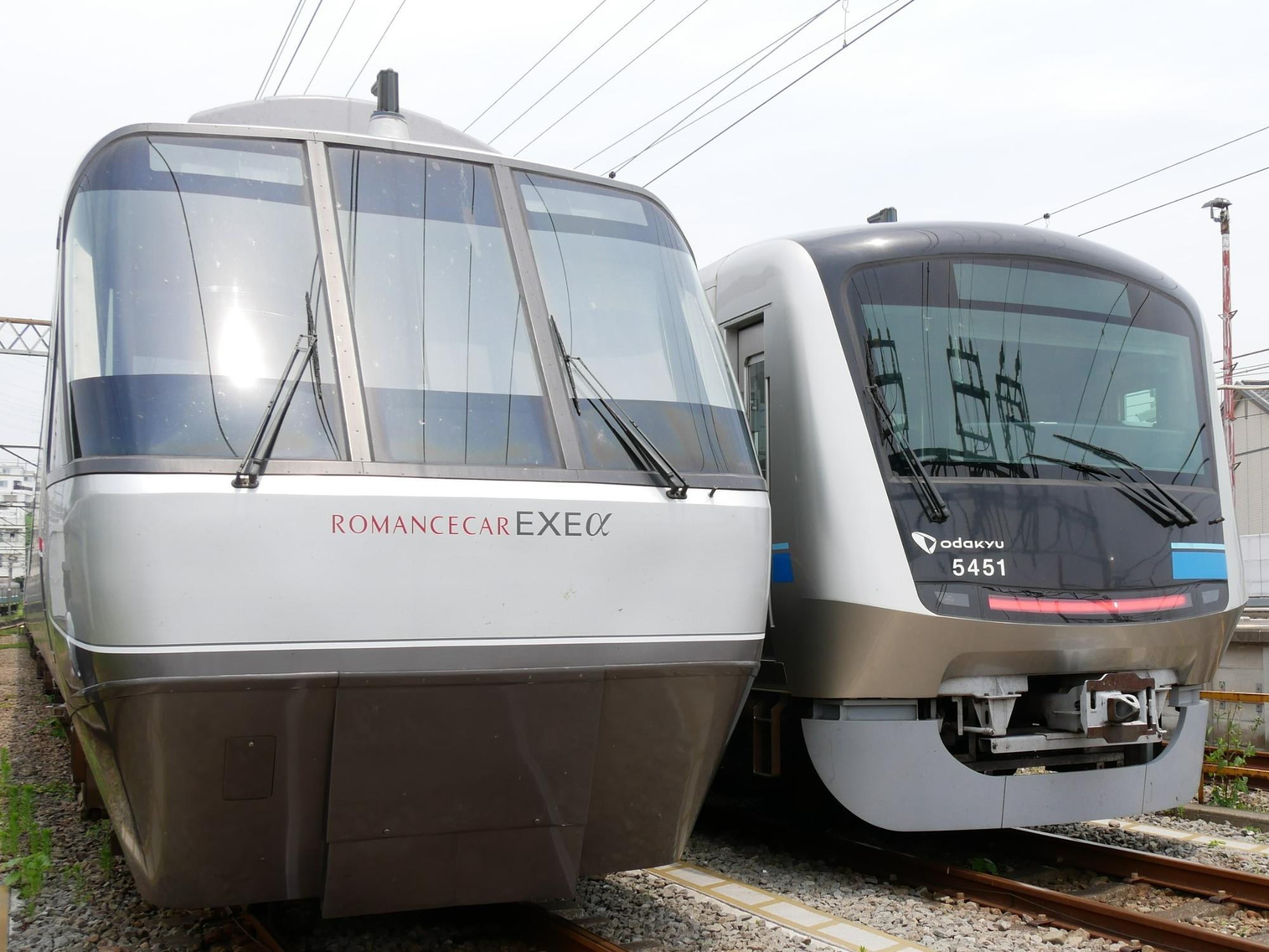 フロントが白とグレーの配色の車両と、フロントガラス周辺が黒の白とグレーの配色の車両が2台並んで停車している様子を正面から撮影した写真