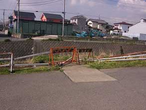 ガードレールの破損部分にオレンジ色の単管バリケードが置かれた写真