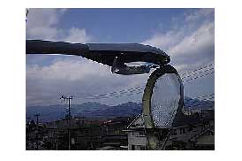 街灯のランプ部分を交換をしている様子を見上げた角度で撮影した写真