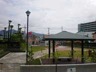 屋根付きの四阿があり、芝生の広場が広がる、さかえちょう公園内の写真