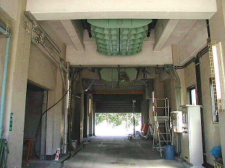 水処理施設の通路から天井に取り付けられた緑色の格子状のホッパーを写した写真