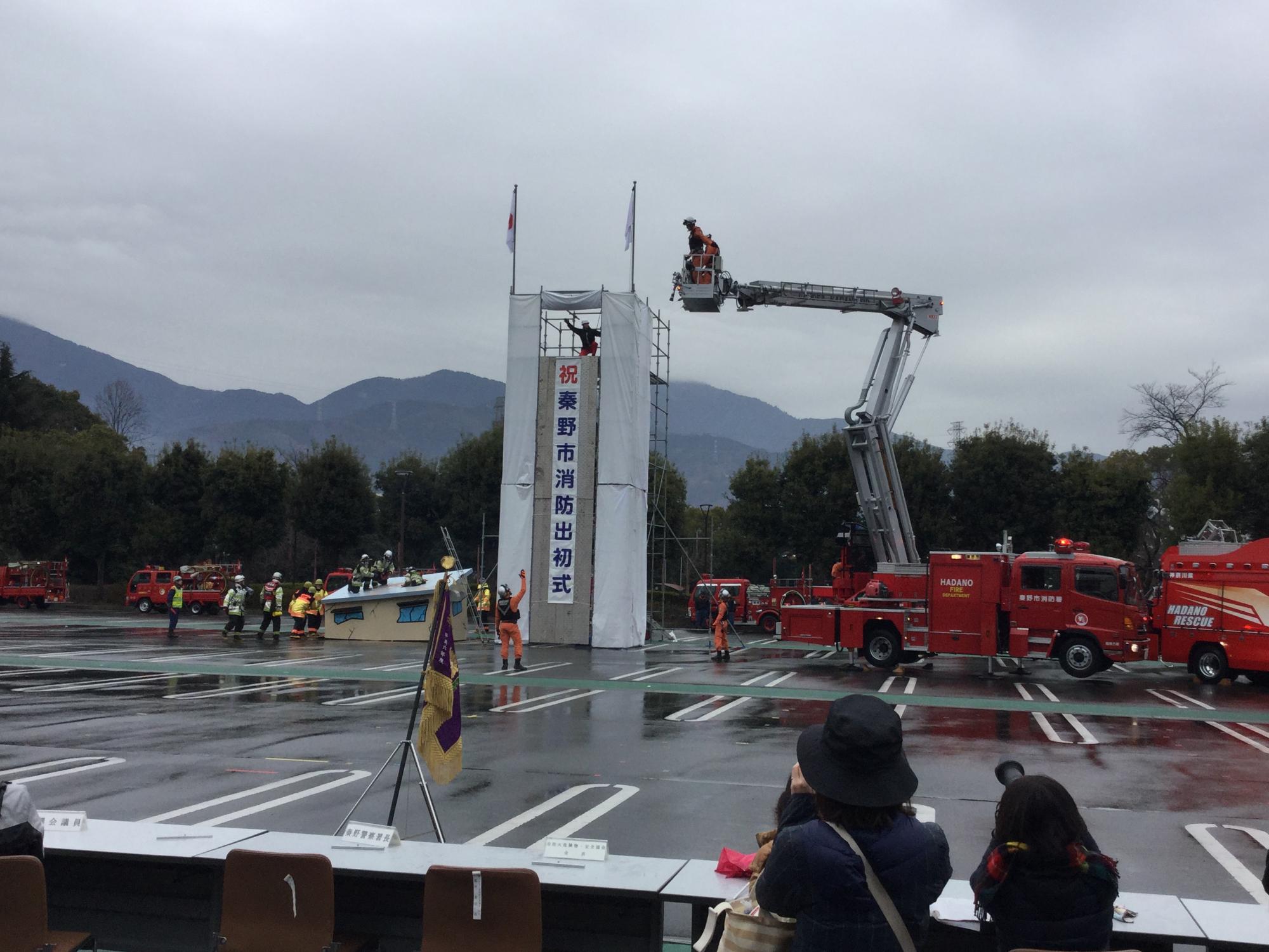 消防隊員達が、はしご車やポンプ車を使って救助訓練を行っている秦野市消防出初式の様子の写真