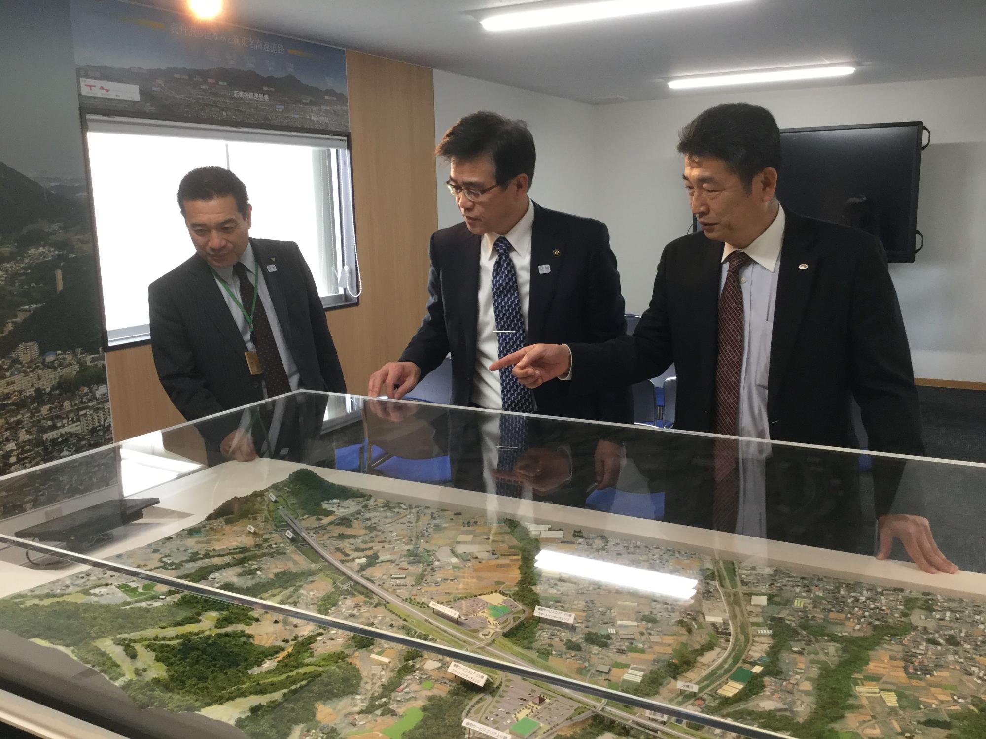完成予想ジオラマを眺めながら説明を受ける市長と関係者の写真