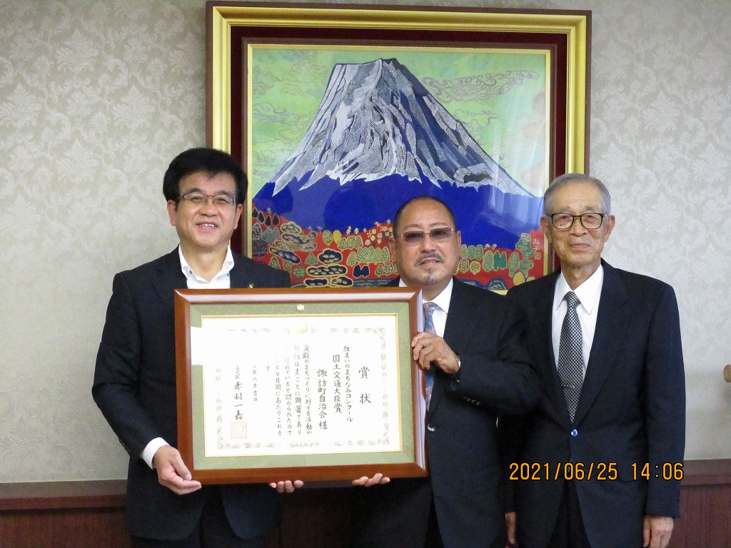 スーツ姿の市長と男性2名が額縁に入った感謝状を持って記念撮影している写真