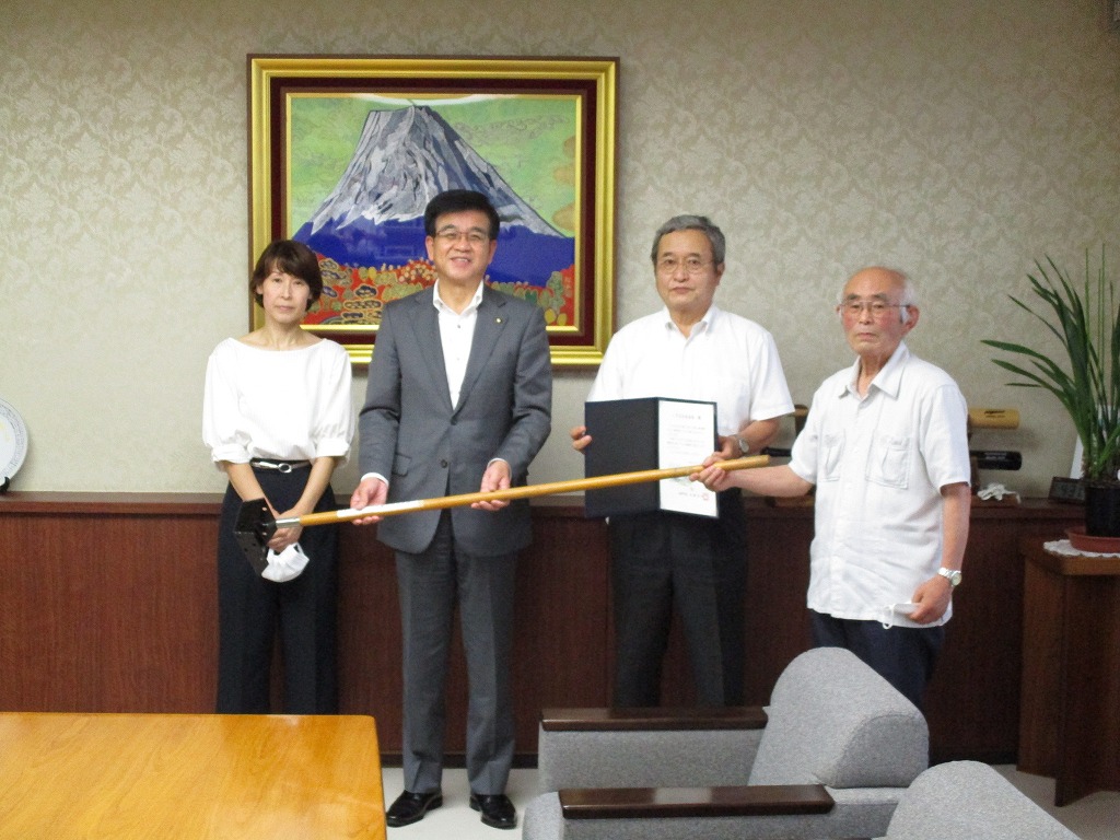 スーツ姿の市長と白いシャツをきた男性2名と女性1名が並んでおり、右から2番目の男性が感謝状をもって記念撮影をしている写真