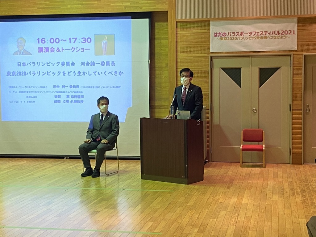 はだのパラスポーツフェスティバルの会場で、演台に立つ高橋市長が、マイクで話している様子を写した写真