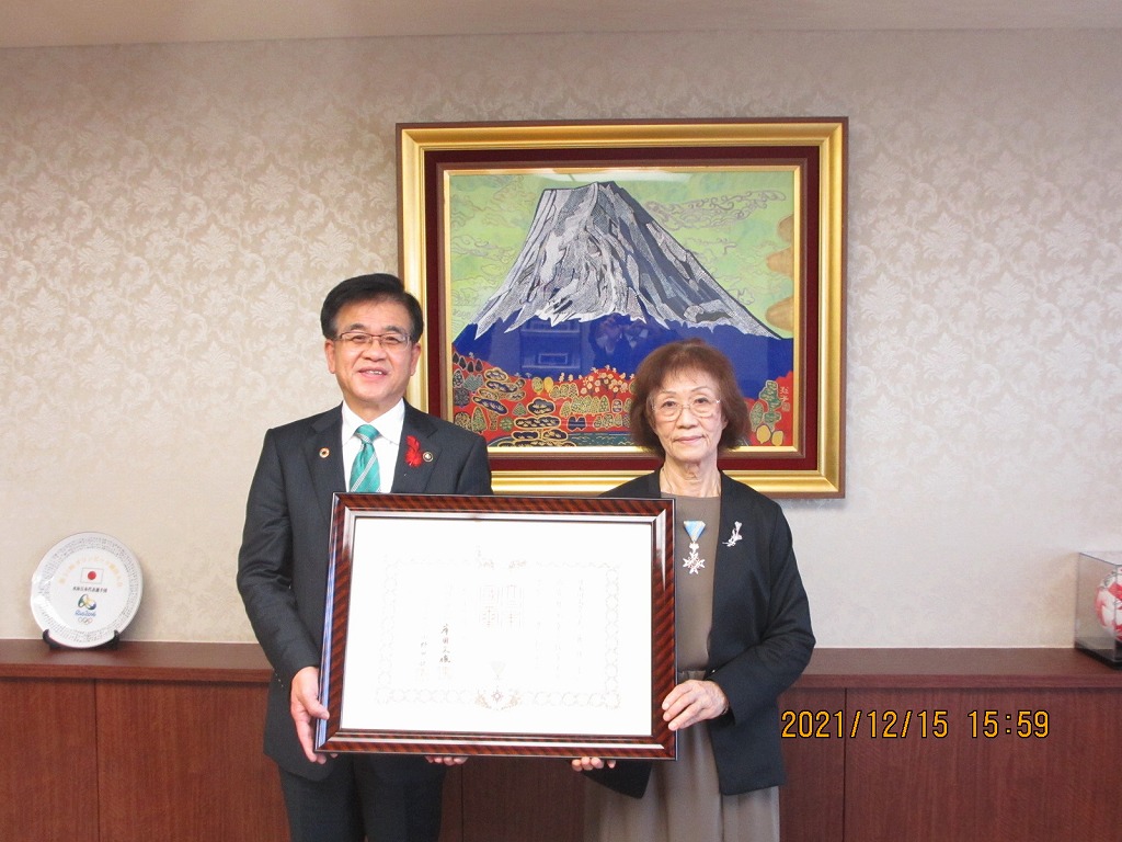 高橋市長と武藤祥子さんが額縁に入った表彰状を一緒に持ち記念撮影を行っている写真