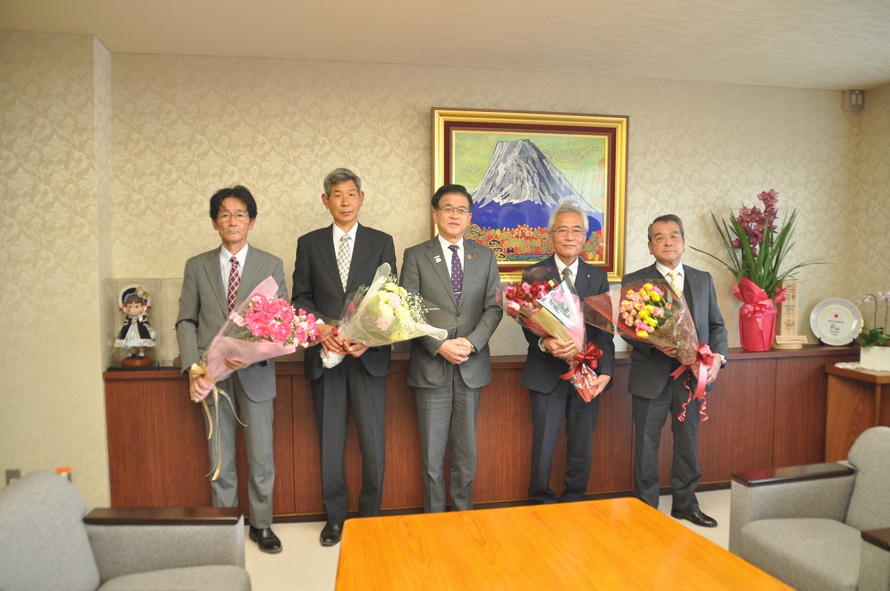 花束を抱えたスーツ姿のJAはだの花き部会の男性4人が市長を中央に並んで立っている記念写真