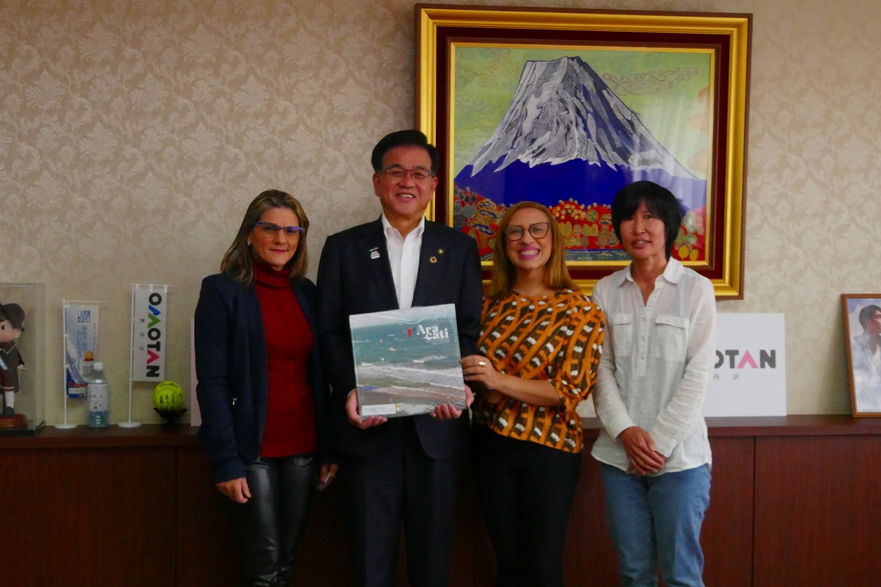 ブラジル共和国アラカチ市教育委員会の女性二名が市長の両隣に並んで立ち、その横に女性が並んで記念撮影をしている写真