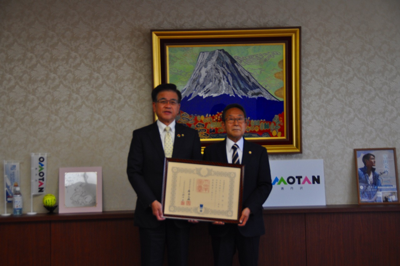 市長と男性が二人で表彰状を持って記念撮影をしている写真