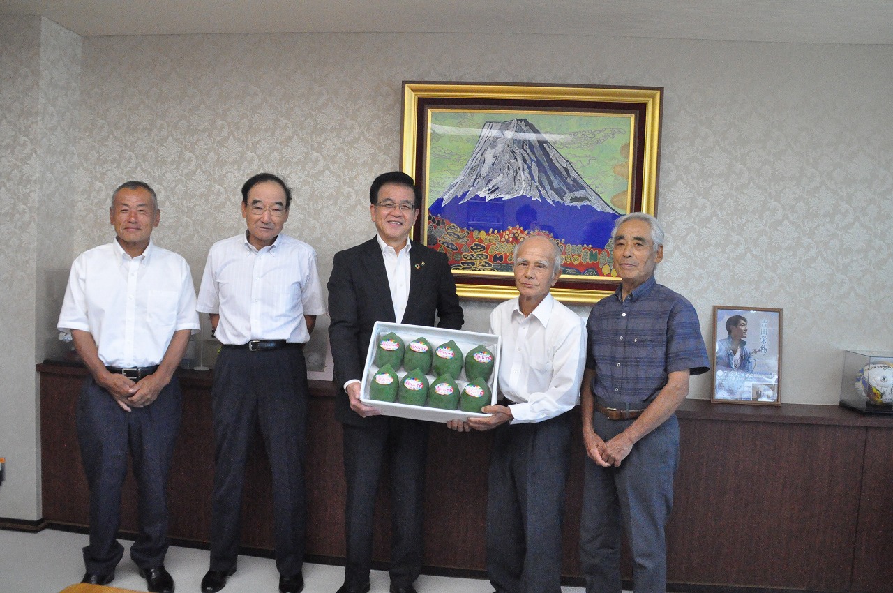 市長と青パパイヤ研究会の代表の方が箱に入った青パパイヤを一緒に持ち、その両サイドに関係者が立ち記念撮影している写真