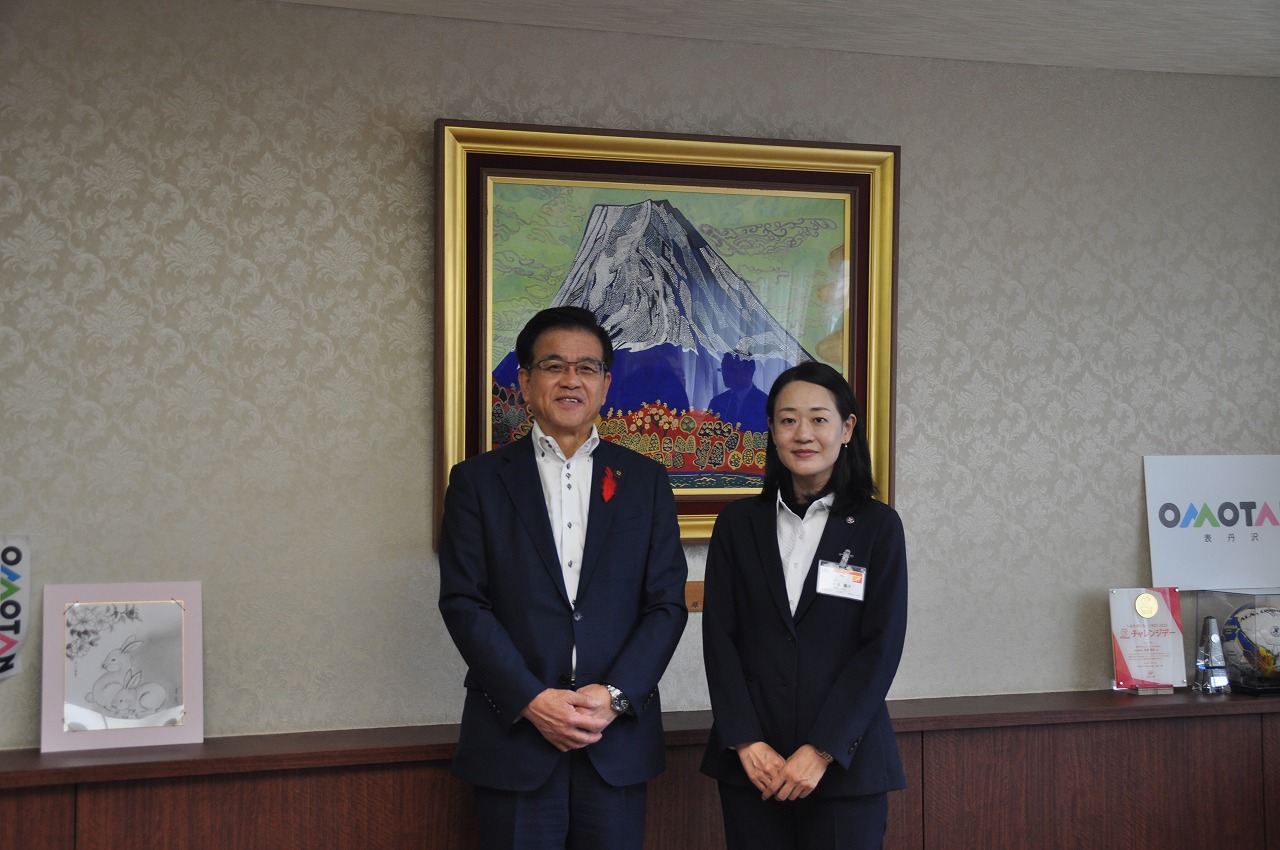 応接室のような部屋で、高橋市長と女性が並んでいる写真