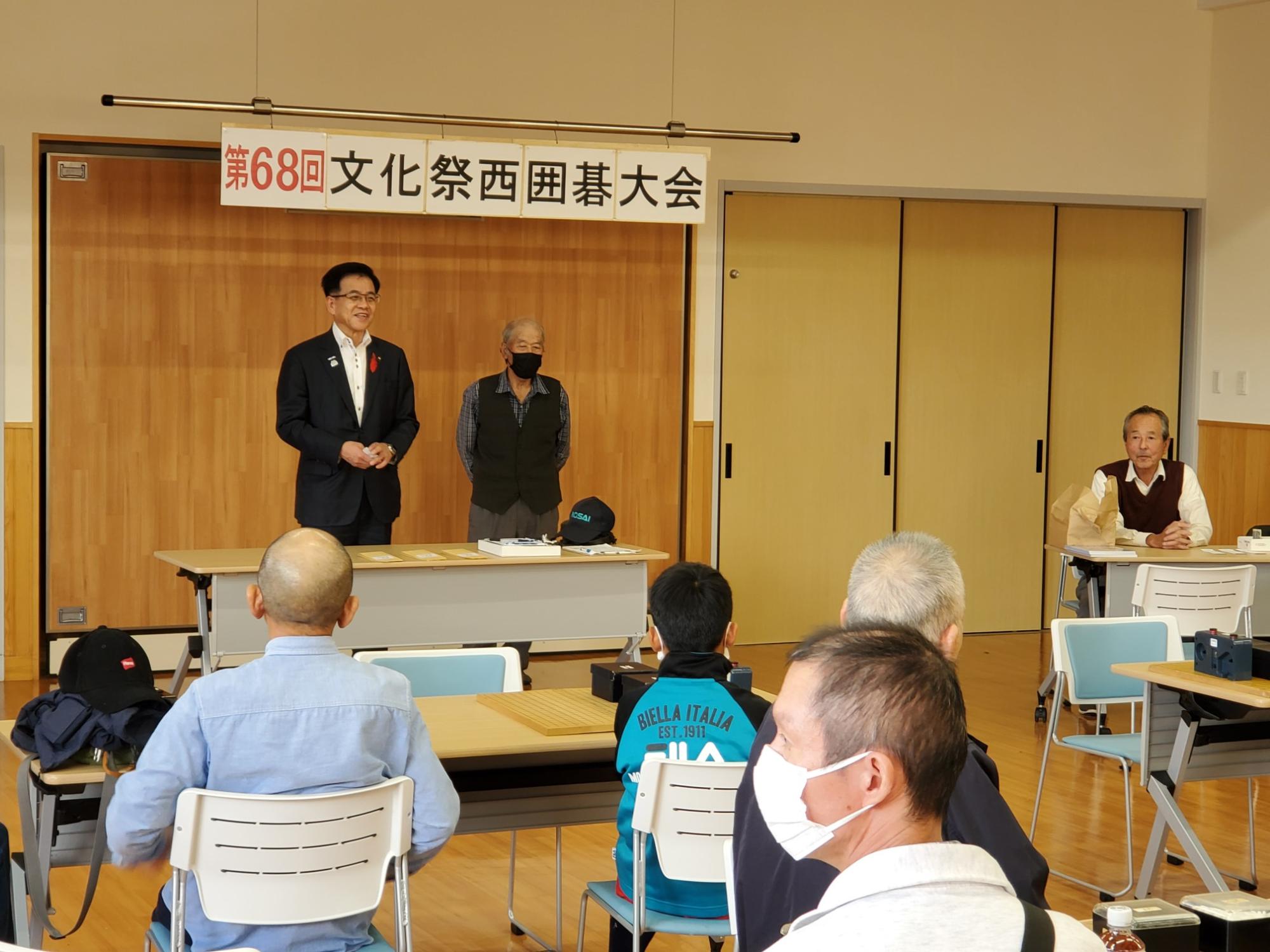 「第68回文化祭囲碁大会」と書かれた横断幕の下に高橋市長と男性が立っており、複数の参加者が着席している写真