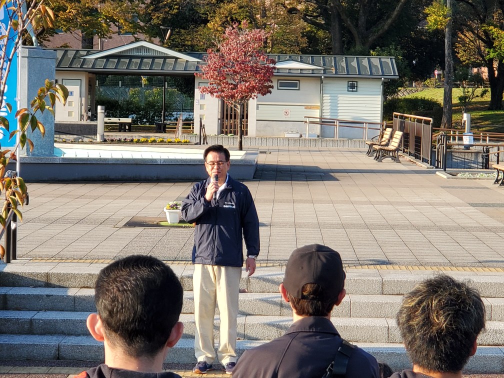 クリーンキャンペーンの屋外の会場で、参加者の方々の前で市長がマイクを持って挨拶を行っている様子の写真