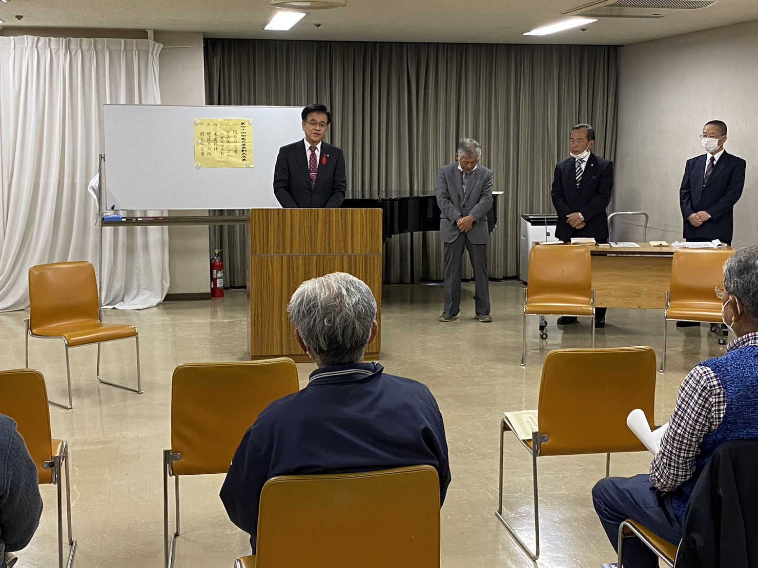文化祭・菊花展表彰式の会場で、壇上に市長が立ち、関係者の方々の前で挨拶を行っている様子の写真