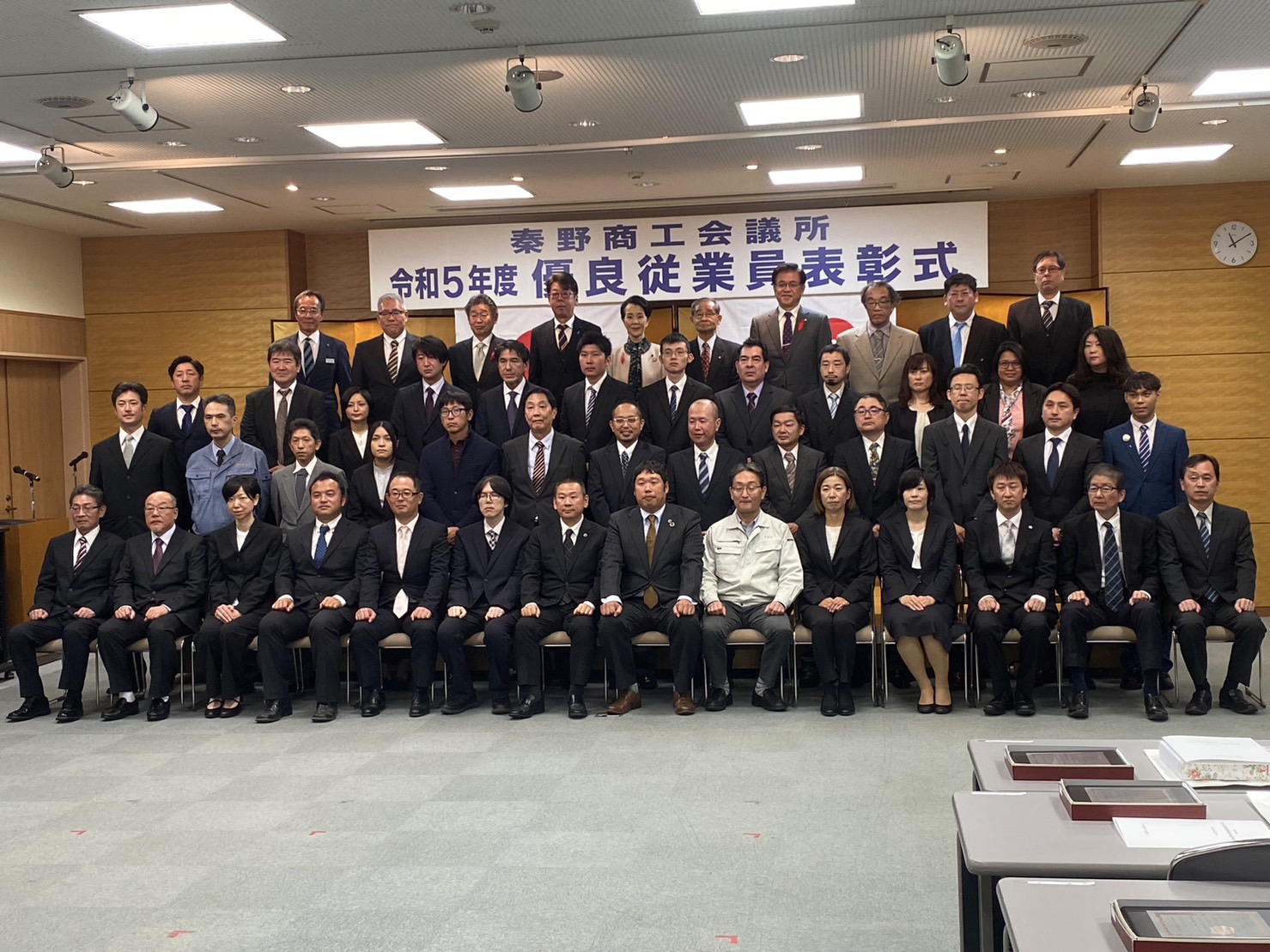 『秦野商工会議所 令和5年度優良従業員表彰式』の横断幕前で、受賞者と関係者が集合し記念撮影を行っている様子の写真
