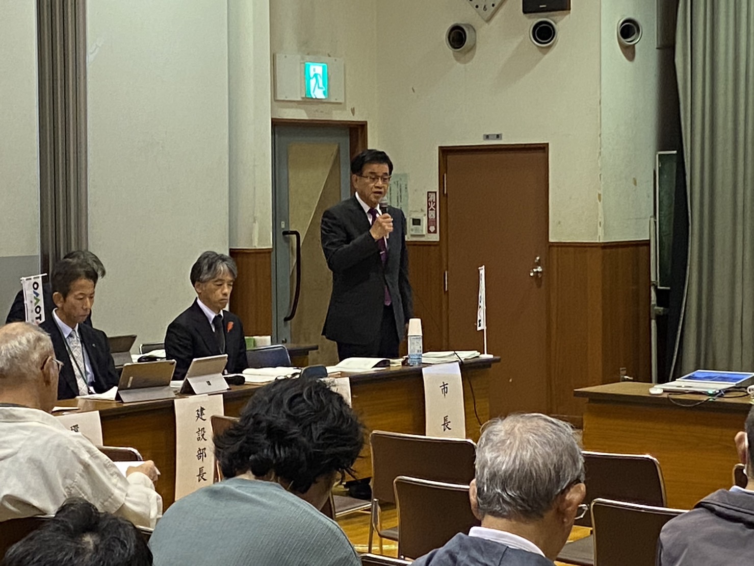 懇親会の会場で、参加者の方々を前に、市長がマイクを持って話をしている様子の写真