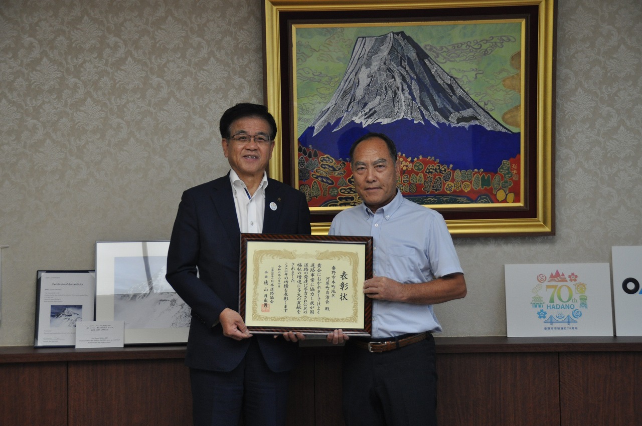 市長と男性が並んで賞状を持ち、記念撮影している写真