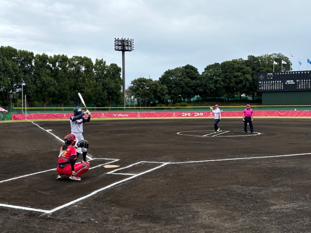 野球場で始球式のようなものが行われており、バッター、キャッチャー、ピッチャー、審判がそれぞれのポジションにいるスポーツ写真