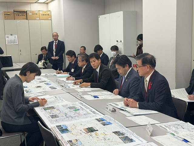 地図が載った資料などを広げた長机を挟み、高橋市長を含む5人の男性が、関係者の女性と向かい合って座り、資料を見ながら話し合いをしている様子の写真