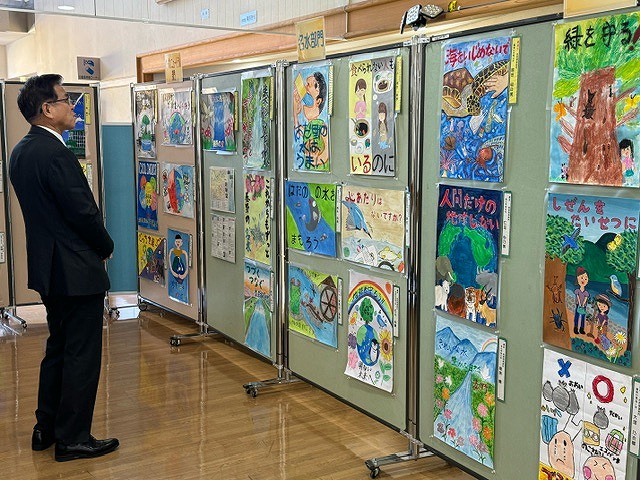 展示スペースに掲示されたたくさんの環境ポスターを高橋市長が熱心に見ている様子の写真