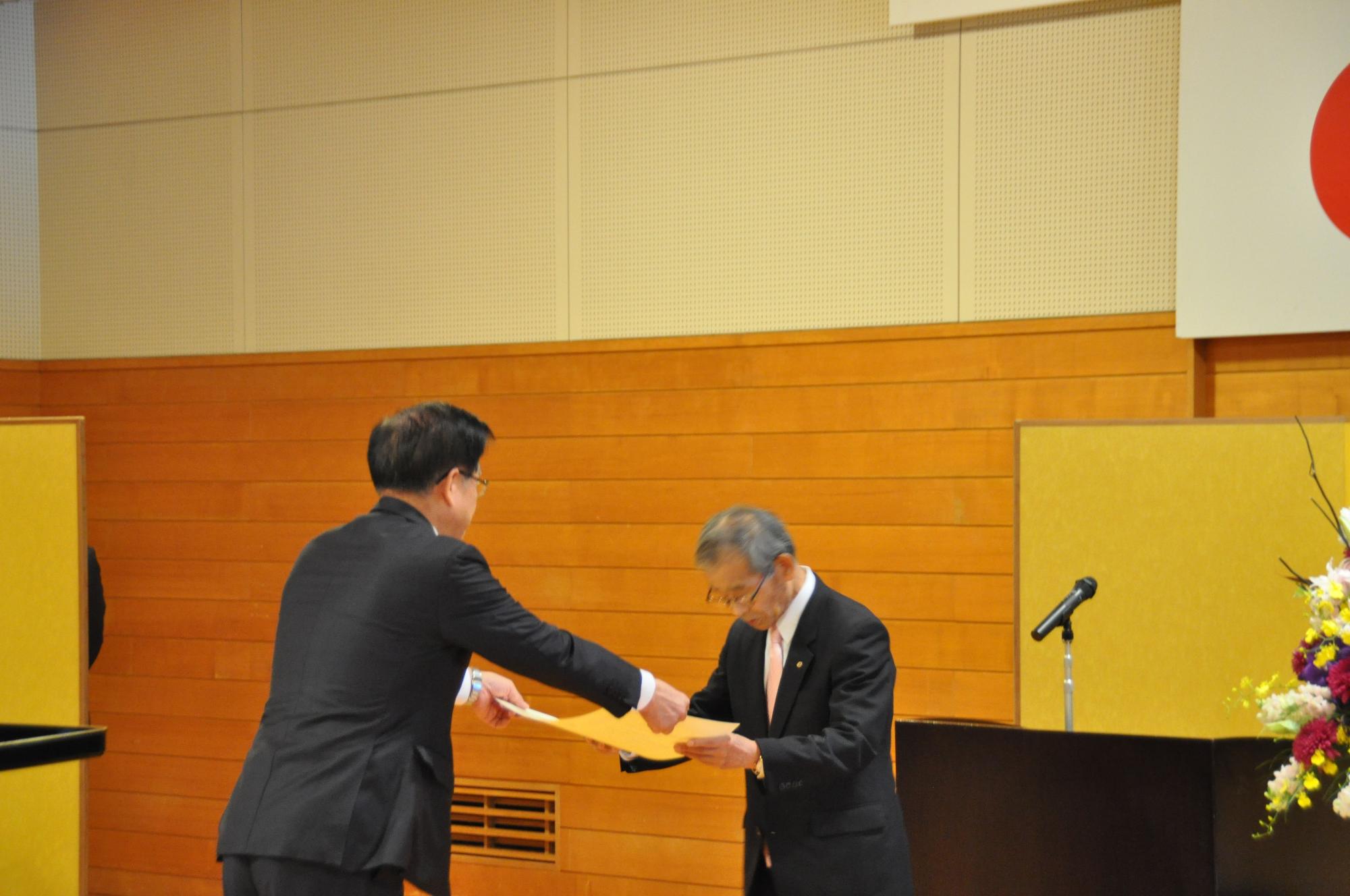 高齢の男性に高橋市長が表彰状を手渡している様子の写真