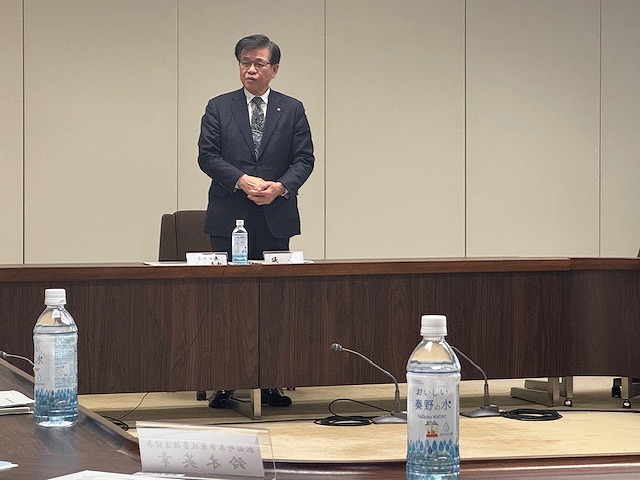 市長が会議室で、テーブルの前に立って挨拶をしている会議風景の写真