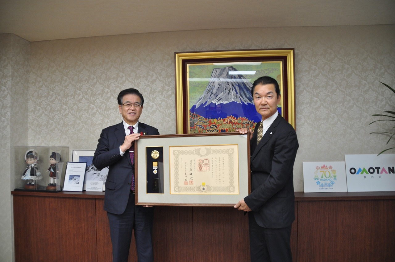 金原利道さんと市長が大きな額縁入りの賞状を一緒に持ち、カメラの方を見て記念撮影をしている写真