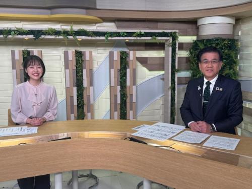座っている市長と左隣にアナウンサーの女性