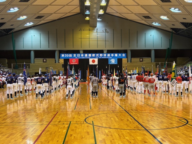 体育館のアリーナに整列した野球のユニフォーム姿の選手たち