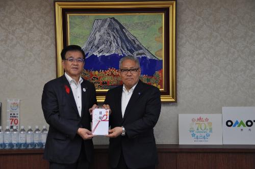 富士山の絵画の前で市長とスーツの男性が目録を一緒に持って立っている