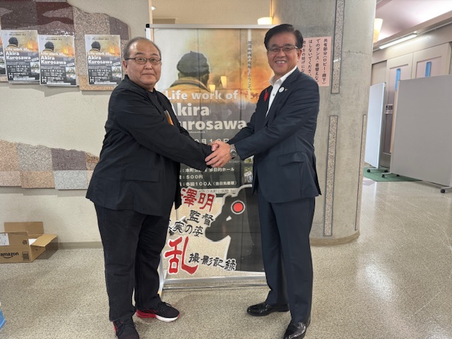 両手で握手をする市長と映画監督の男性