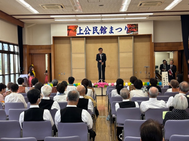 壇上で挨拶する市長とそれを座って聞く来場者、来場者は発表会のための衣装を着ている