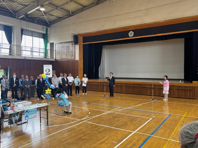 学校の体育館で挨拶する市長を遠くから写した写真
