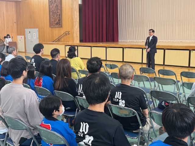 椅子に座る大勢の市民の前で挨拶する市長