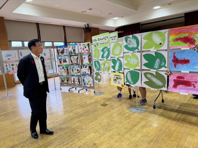 屋内で絵の展示を見学する市長