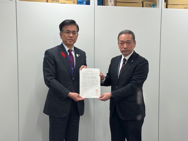 市長とスーツの男性が一緒に要望書を持って立っている