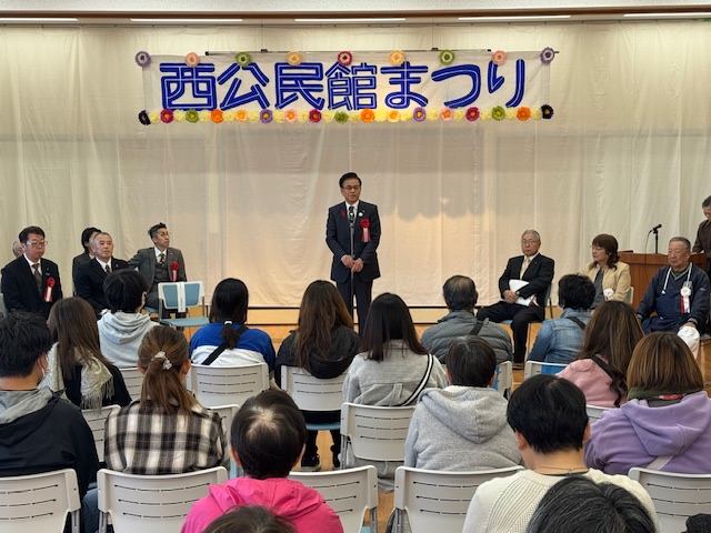 椅子に座る多数の市民を前に挨拶する市長