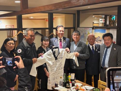 テコンドーの動議を持つ市長と女性選手、応援団の男性4人と女性1人