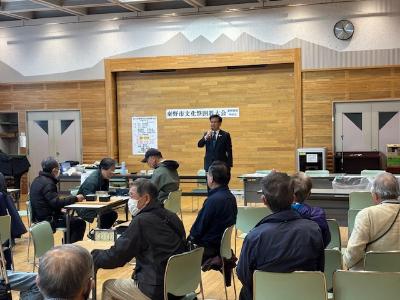 奥に挨拶する市長、手前に囲碁を打つ年配の男性が多数