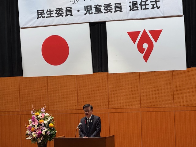 演台で挨拶をする市長、背後には国旗、市旗が掲げられている。