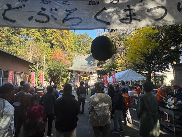 神社の前に集まった大勢の市民、上にどぶろくまつりの手書きの横断幕がある。