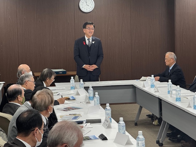 スーツの自治会会長たちの前で挨拶する市長