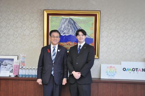 富士山の絵の前で市長とスーツの男性が立っている。